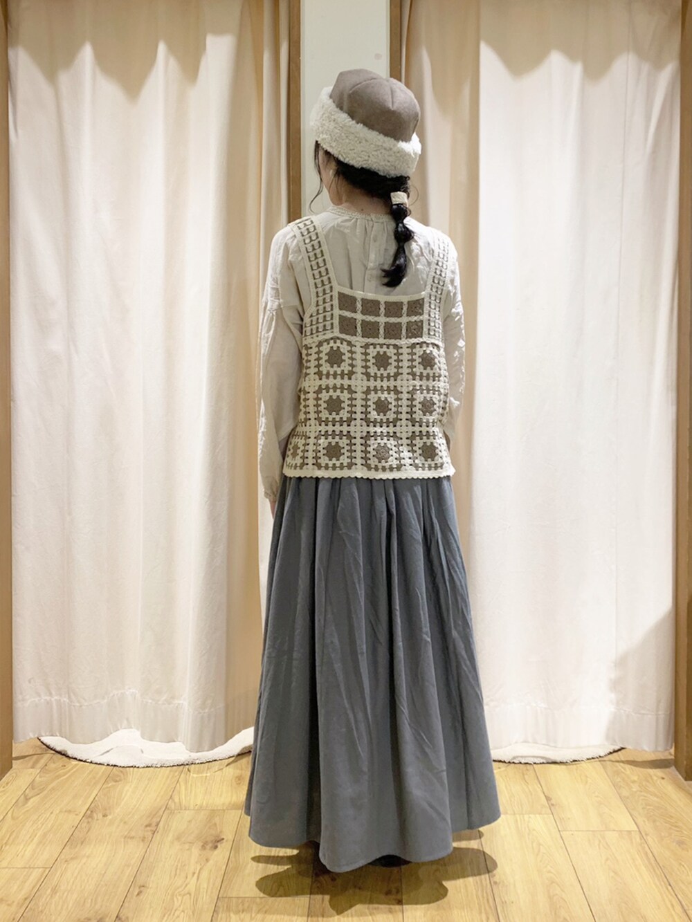 ホワイト系のベスト、ホワイト系のシャツ/ブラウス、グリーン系のスカートを着用したレディースの秋コーディネートの3枚目の写真