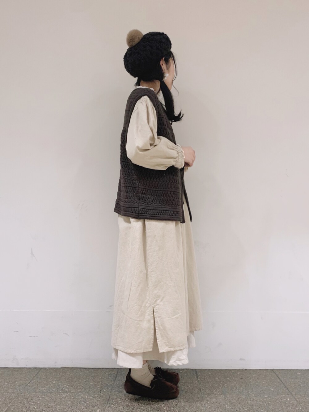 ブラウン系のベスト、ホワイト系のワンピース、ベージュ系のTシャツ/カットソーを着用したレディースの冬コーディネートの3枚目の写真