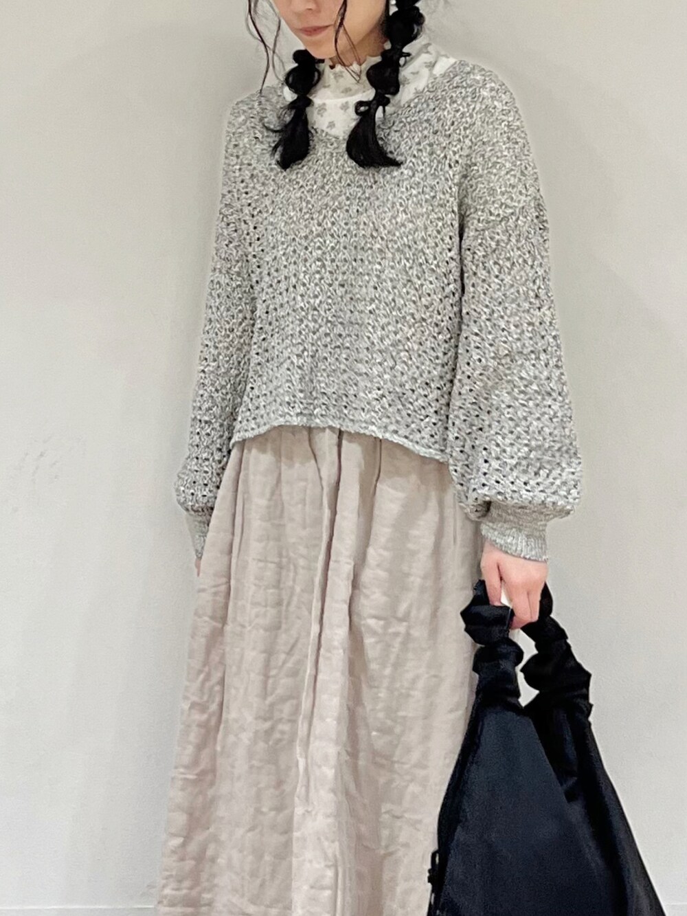 ブルー系のTシャツ/カットソー、ブラック系のカーディガン/ボレロ、ベージュ系のスカートを着用したレディースの冬コーディネートの5枚目の写真