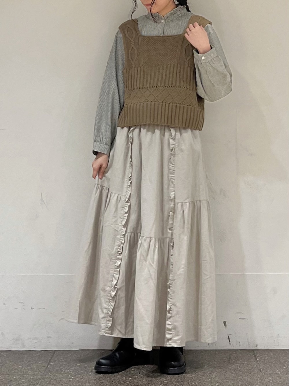 ベージュ系のベスト、ブラック系のシャツ/ブラウス、ベージュ系のスカートを着用したレディースの冬コーディネートの2枚目の写真