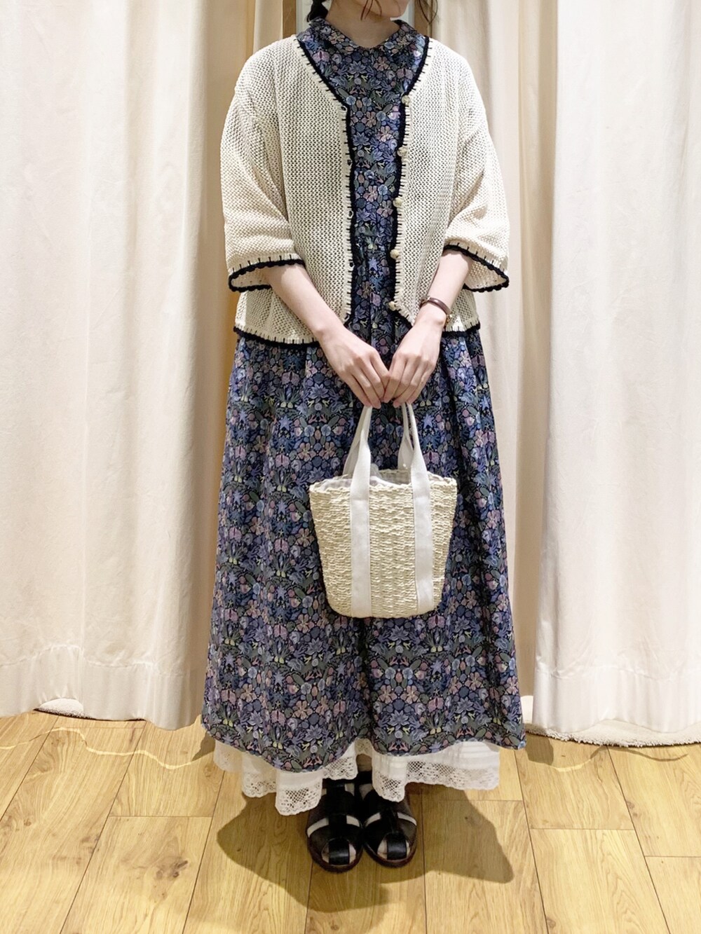 ブルー系のワンピース、ブラック系のサンダル、ホワイト系のスカートを着用したレディースの春コーディネートの2枚目の写真