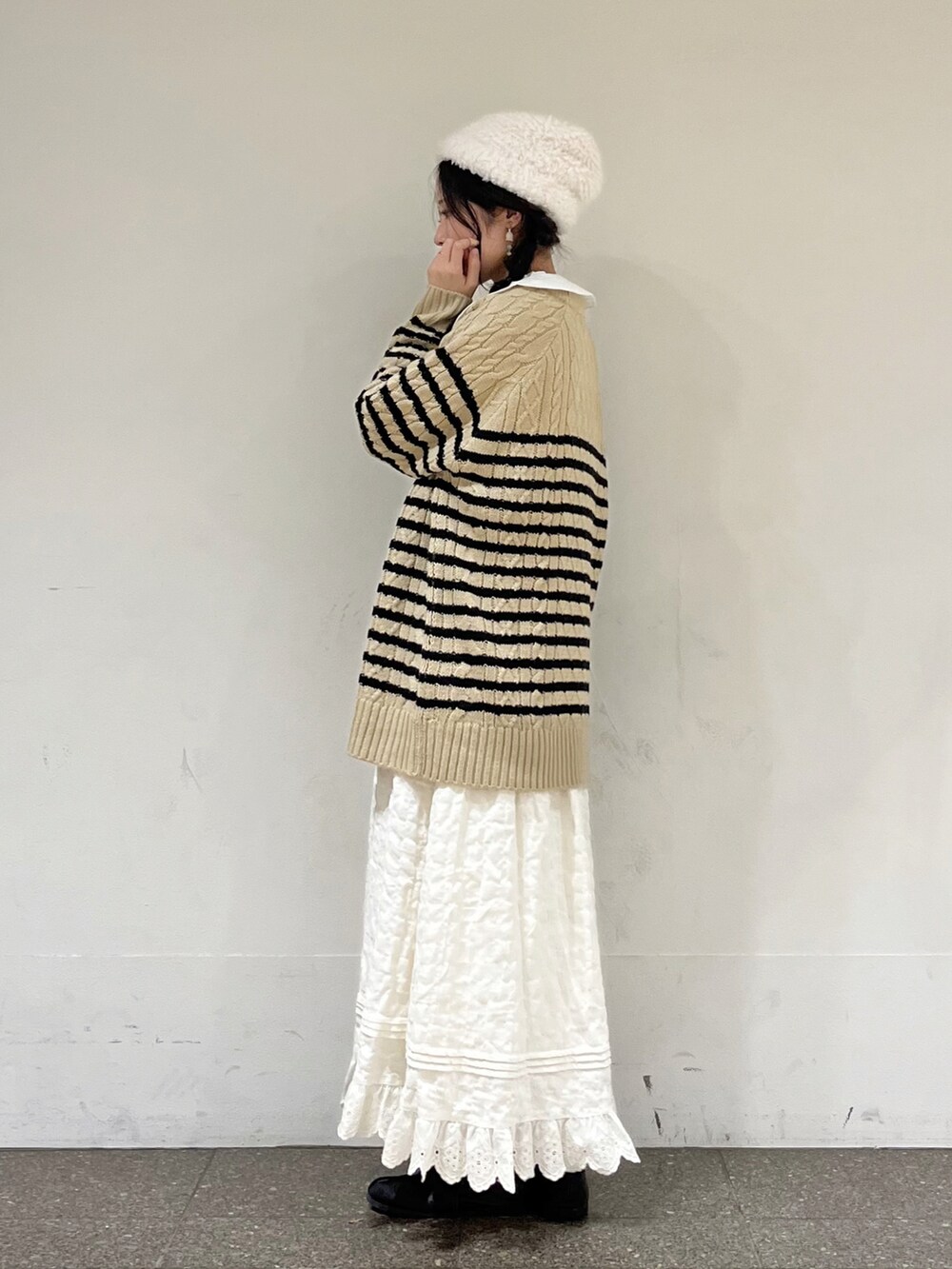 ベージュ系のニット/セーター、ホワイト系のシャツ/ブラウス、ホワイト系のスカートを着用したレディースの冬コーディネートの3枚目の写真