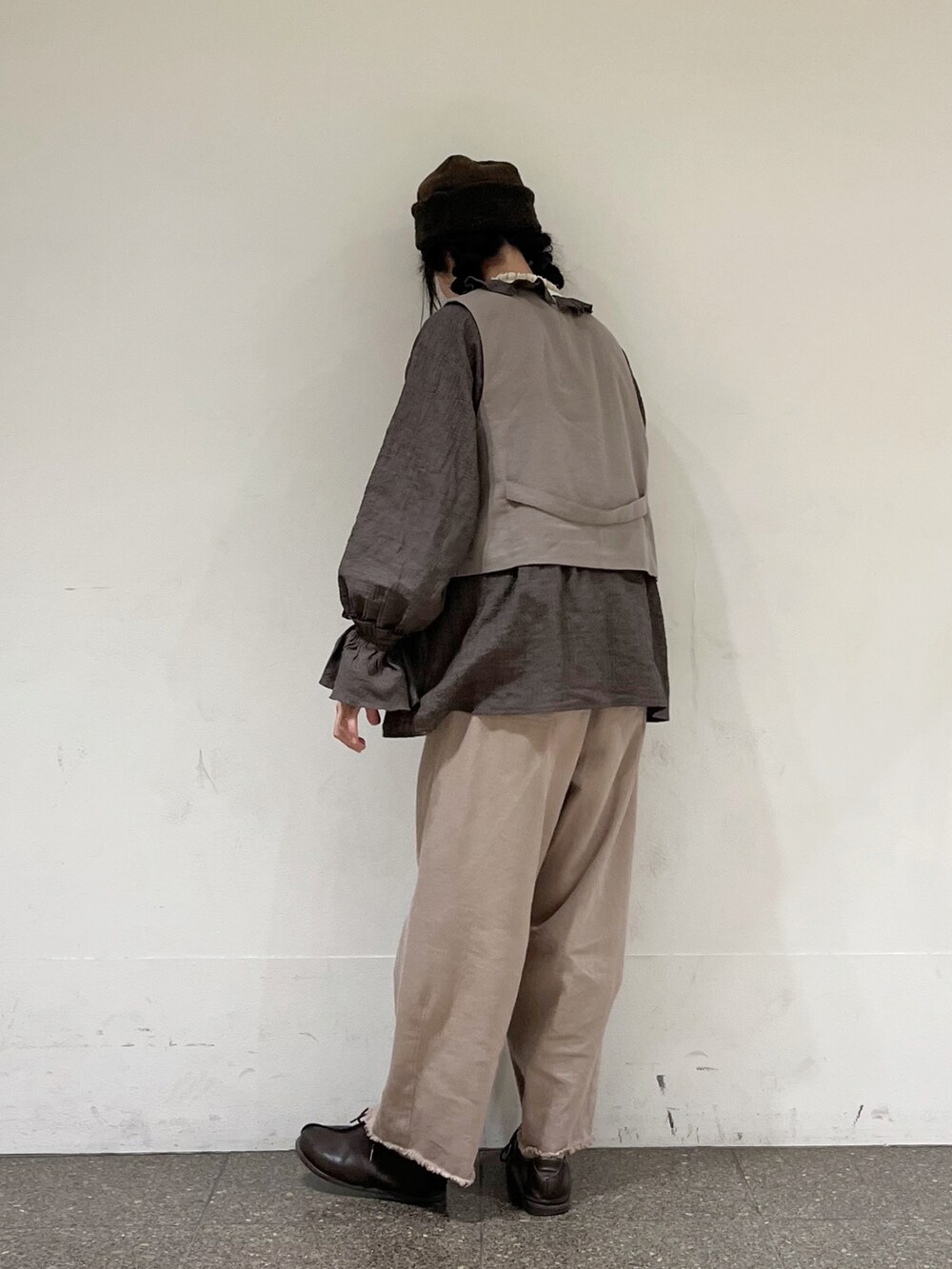 ブラウン系のシャツ/ブラウス、ブラウン系のベスト、ホワイト系のニット/セーターを着用したレディースの冬コーディネートの4枚目の写真