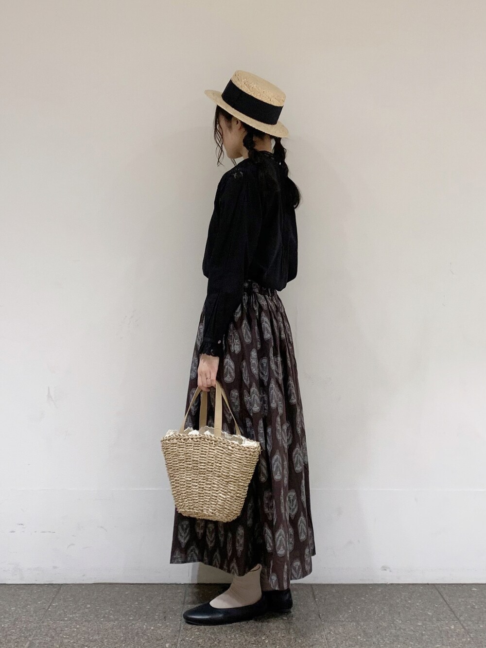 ブラック系のシャツ/ブラウス、ブラウン系のスカート、ベージュ系のハンドバッグを着用したレディースの夏コーディネートの2枚目の写真