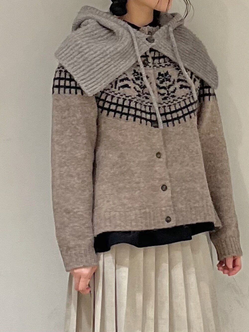 ブラウン系のカーディガン/ボレロ、ブラック系のシャツ/ブラウス、ベージュ系のスカートを着用したレディースの冬コーディネートの4枚目の写真