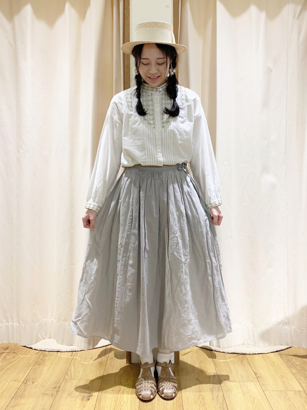 ホワイト系のシャツ/ブラウス、ホワイト系のカーディガン/ボレロ、グレー系のスカートを着用したレディースの春コーディネートの3枚目の写真