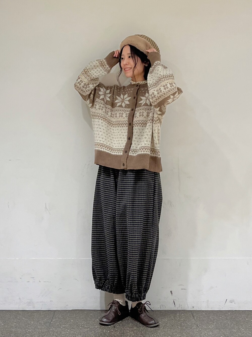 ブラウン系のカーディガン/ボレロ、ホワイト系のニット/セーター、ブラウン系のその他パンツを着用したレディースの冬コーディネートの2枚目の写真