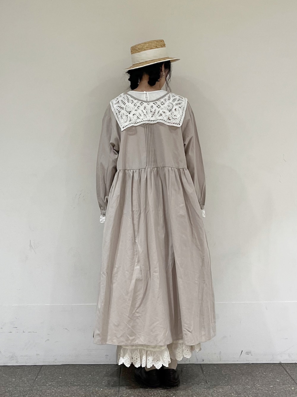 ホワイト系のワンピース、ホワイト系のスカート、ブラウン系のハンドバッグを着用したレディースの冬コーディネートの5枚目の写真