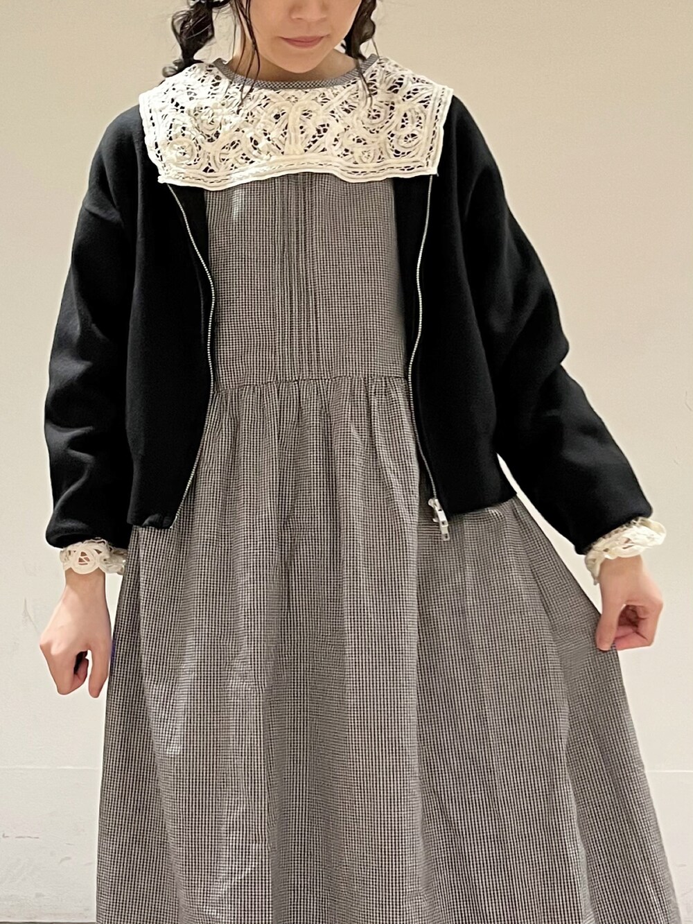 グレー系のワンピース、ブラック系のカーディガン/ボレロ、グレー系のスカートを着用したレディースの春コーディネートの5枚目の写真