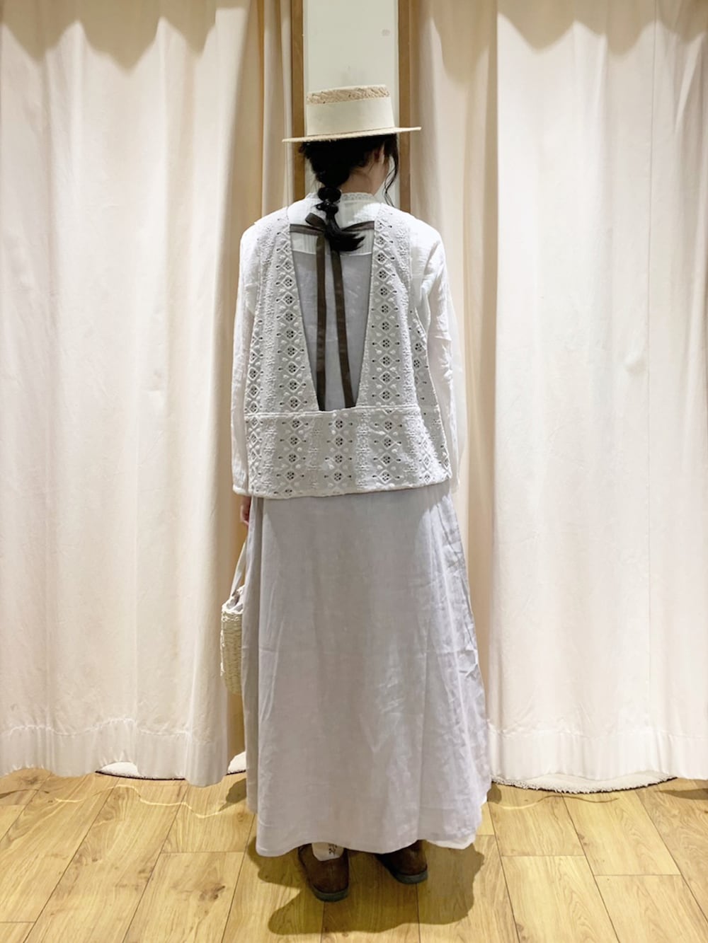 グレー系のワンピース、ホワイト系のベスト、ホワイト系のスカートを着用したレディースの春コーディネートの4枚目の写真