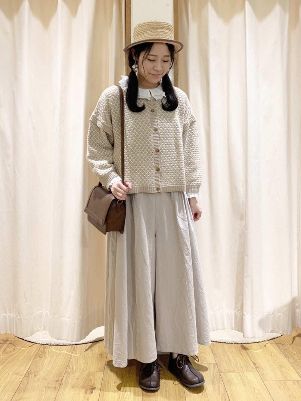 ベージュ系のニット/セーター、ホワイト系のシャツ/ブラウス、ベージュ系のその他パンツを着用したレディースの春コーディネートの2枚目の写真