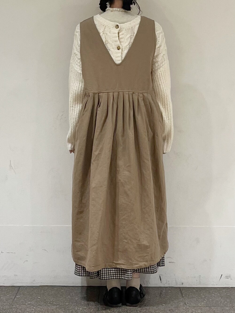 ホワイト系のカーディガン/ボレロ、ホワイト系のニット/セーター、ベージュ系のワンピースを着用したレディースの冬コーディネートの4枚目の写真