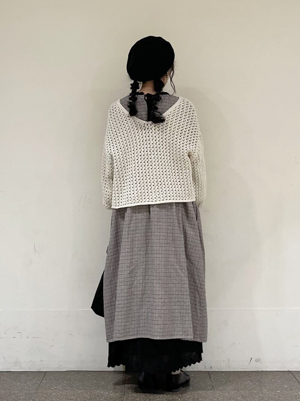 ブラック系のワンピース、ベージュ系のカーディガン/ボレロ、ブラック系のスカートを着用したレディースの冬コーディネートの5枚目の写真