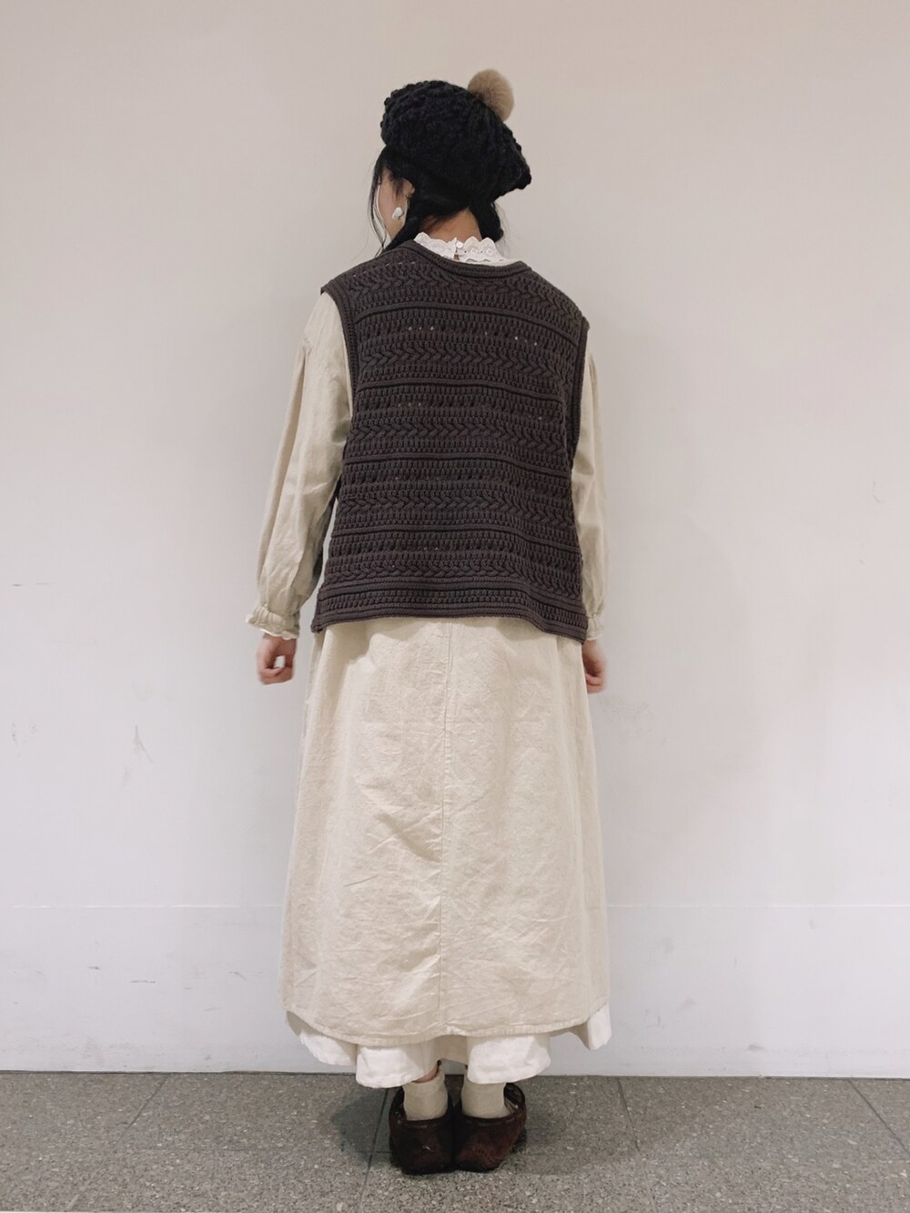 ブラウン系のベスト、ホワイト系のワンピース、ベージュ系のTシャツ/カットソーを着用したレディースの冬コーディネートの4枚目の写真