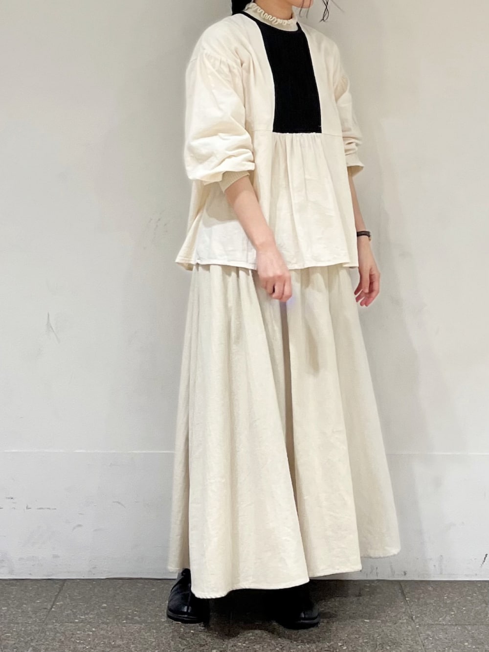 ホワイト系のシャツ/ブラウス、ベージュ系のスカートを着用したレディースの冬コーディネートの2枚目の写真