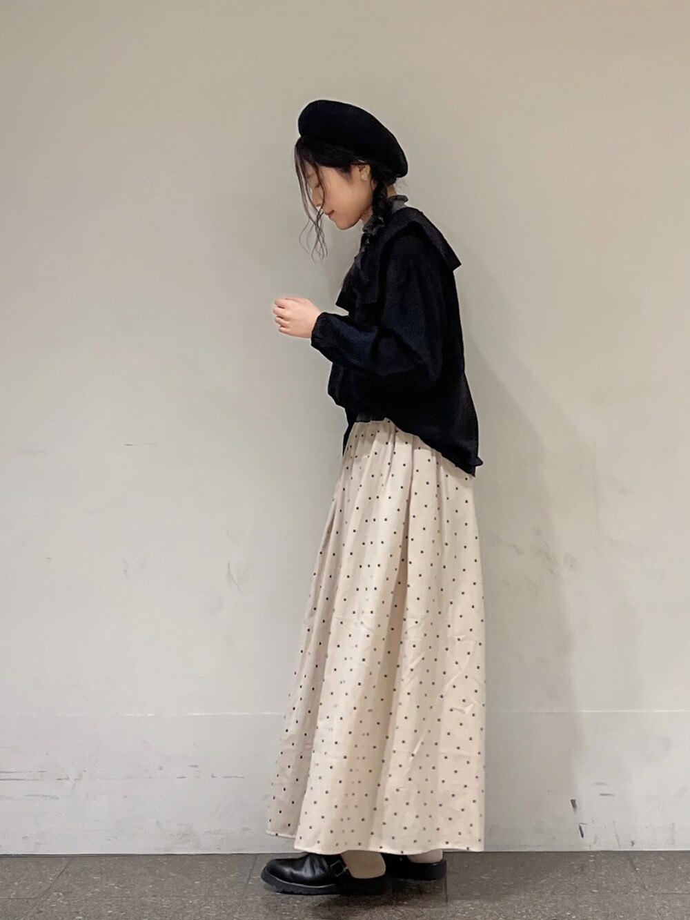 ブラック系のシャツ/ブラウス、グレー系のニット/セーター、ホワイト系のスカートを着用したレディースの秋コーディネートの2枚目の写真