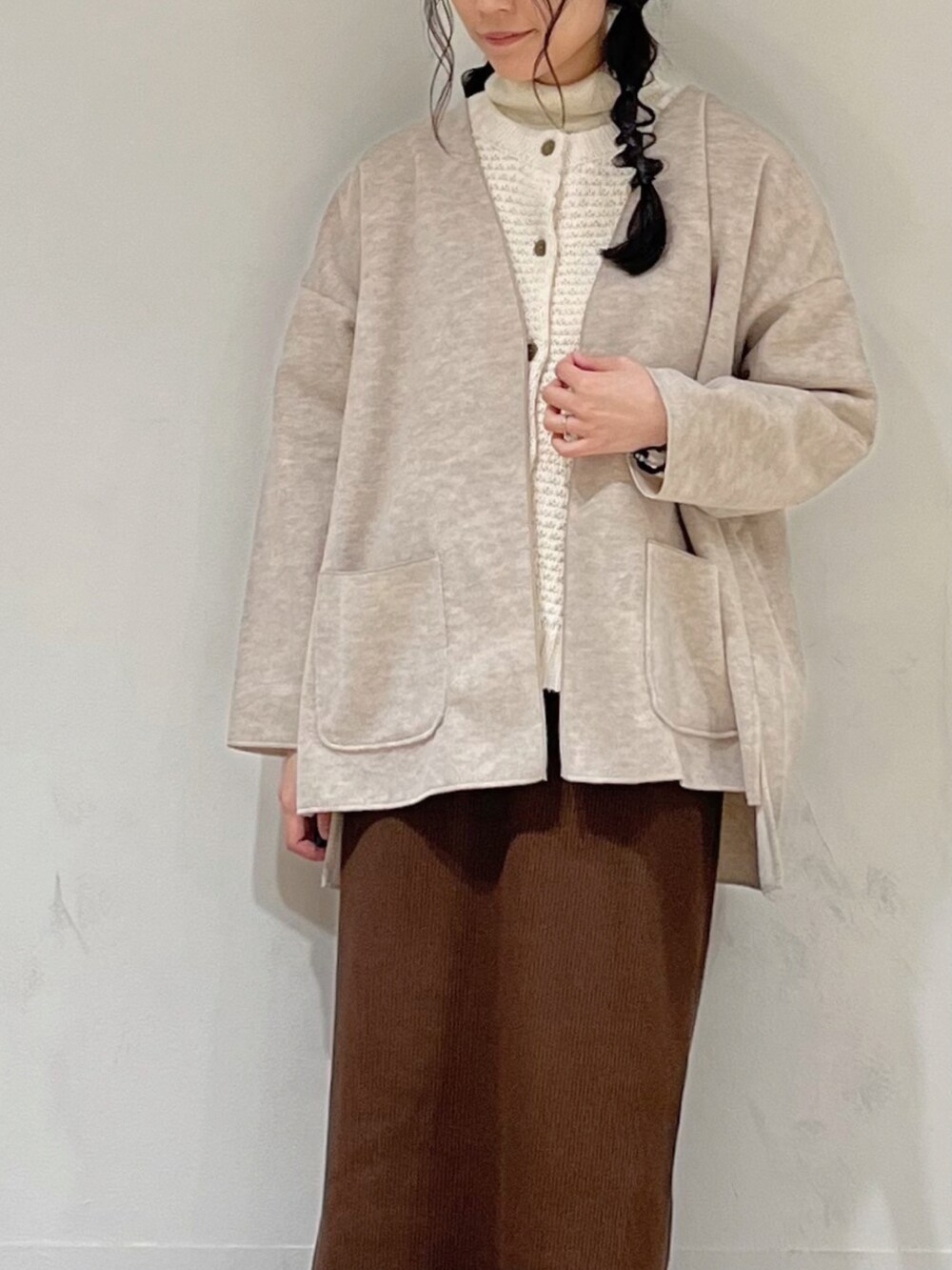 ブラウン系のスカート、ホワイト系のカーディガン/ボレロ、ベージュ系のノーカラージャケットを着用したレディースの秋コーディネートの5枚目の写真