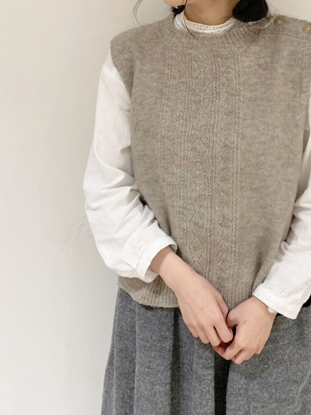 ベージュ系のベスト、ホワイト系のシャツ/ブラウス、ブラック系のスカートを着用したレディースの秋コーディネートの4枚目の写真