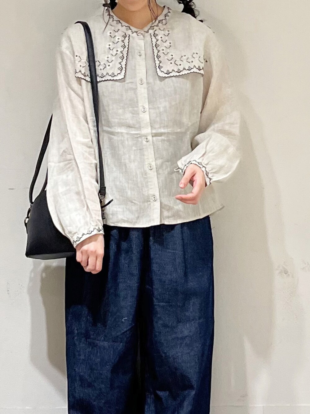 ベージュ系のシャツ/ブラウス、ブルー系のデニムパンツ、ブラック系のハンドバッグを着用したレディースの冬コーディネートの4枚目の写真