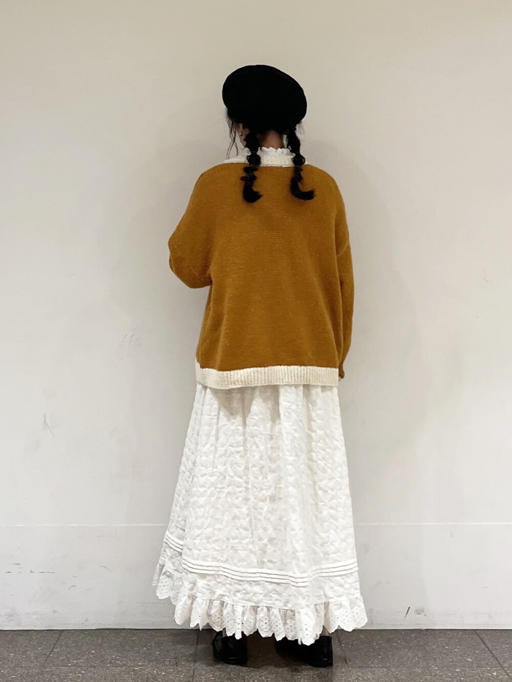 ホワイト系のシャツ/ブラウス、イエロー系のカーディガン/ボレロ、ホワイト系のスカートを着用したレディースの冬コーディネートの4枚目の写真