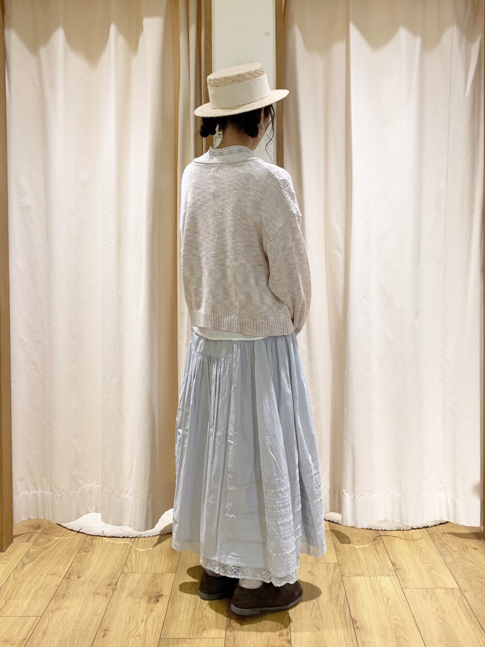 ホワイト系のカーディガン/ボレロ、ホワイト系のシャツ/ブラウス、ブルー系のスカートを着用したレディースの春コーディネートの4枚目の写真