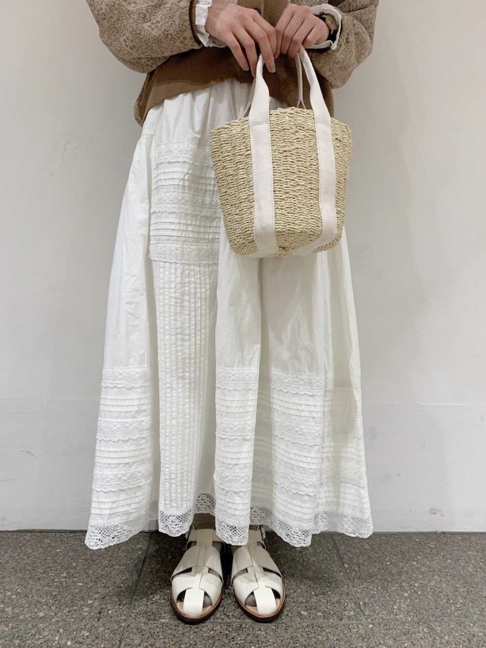 ベージュ系のカーディガン/ボレロ、ホワイト系のシャツ/ブラウス、ホワイト系のスカートを着用したレディースの春コーディネートの5枚目の写真