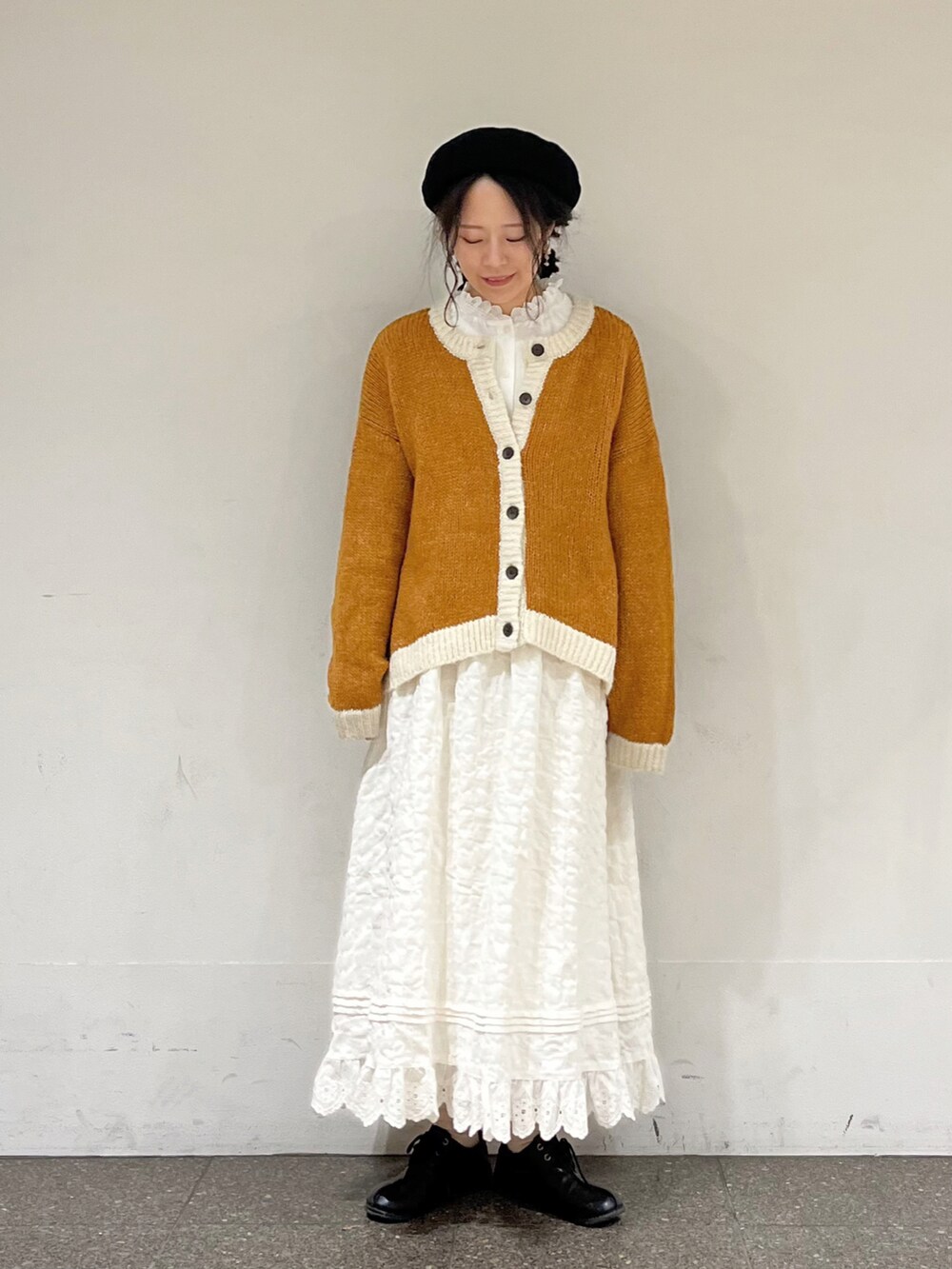 ホワイト系のシャツ/ブラウス、イエロー系のカーディガン/ボレロ、ホワイト系のスカートを着用したレディースの冬コーディネートの2枚目の写真