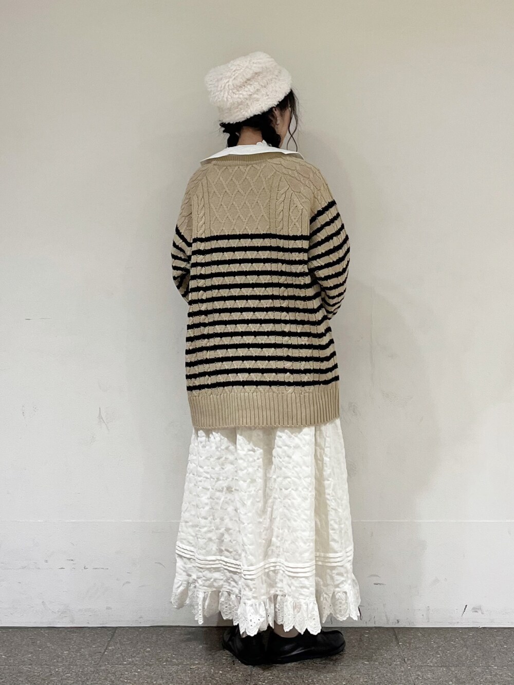 ベージュ系のニット/セーター、ホワイト系のシャツ/ブラウス、ホワイト系のスカートを着用したレディースの冬コーディネートの4枚目の写真