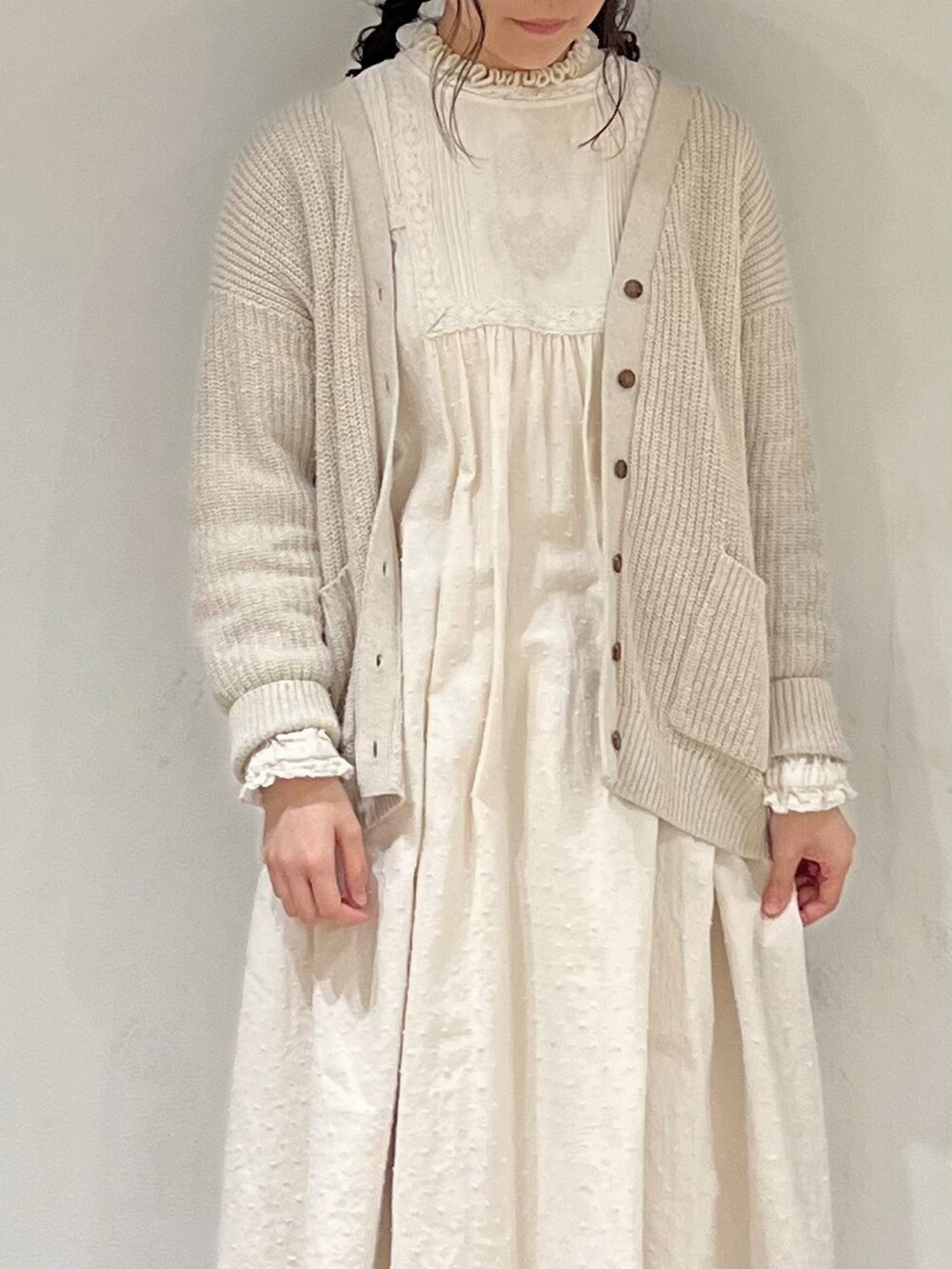 ホワイト系のワンピース、ホワイト系のニット/セーター、ベージュ系のスカートを着用したレディースの冬コーディネートの5枚目の写真