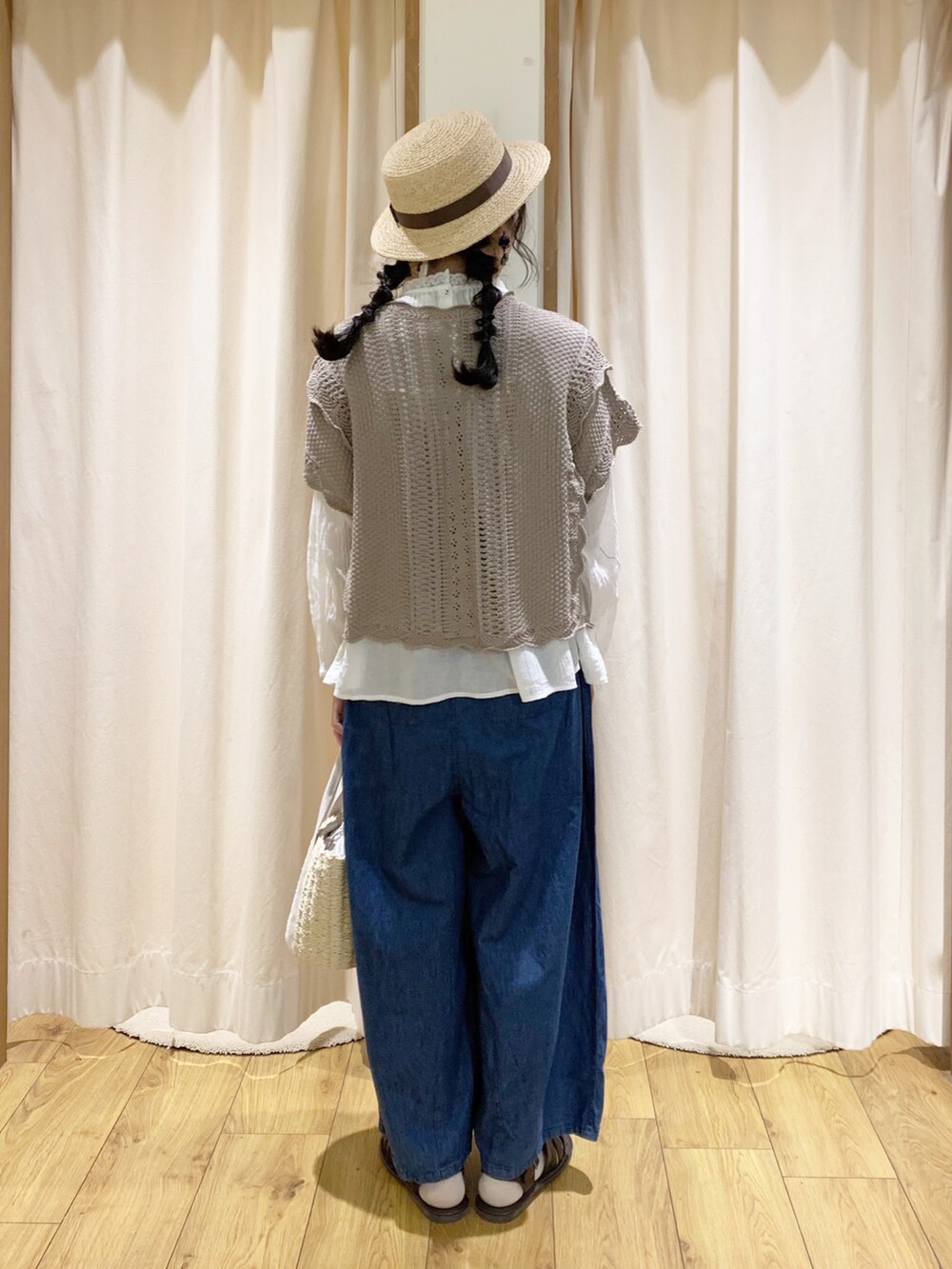 ブラウン系のベスト、ホワイト系のシャツ/ブラウス、ブルー系のデニムパンツを着用したレディースの春コーディネートの4枚目の写真