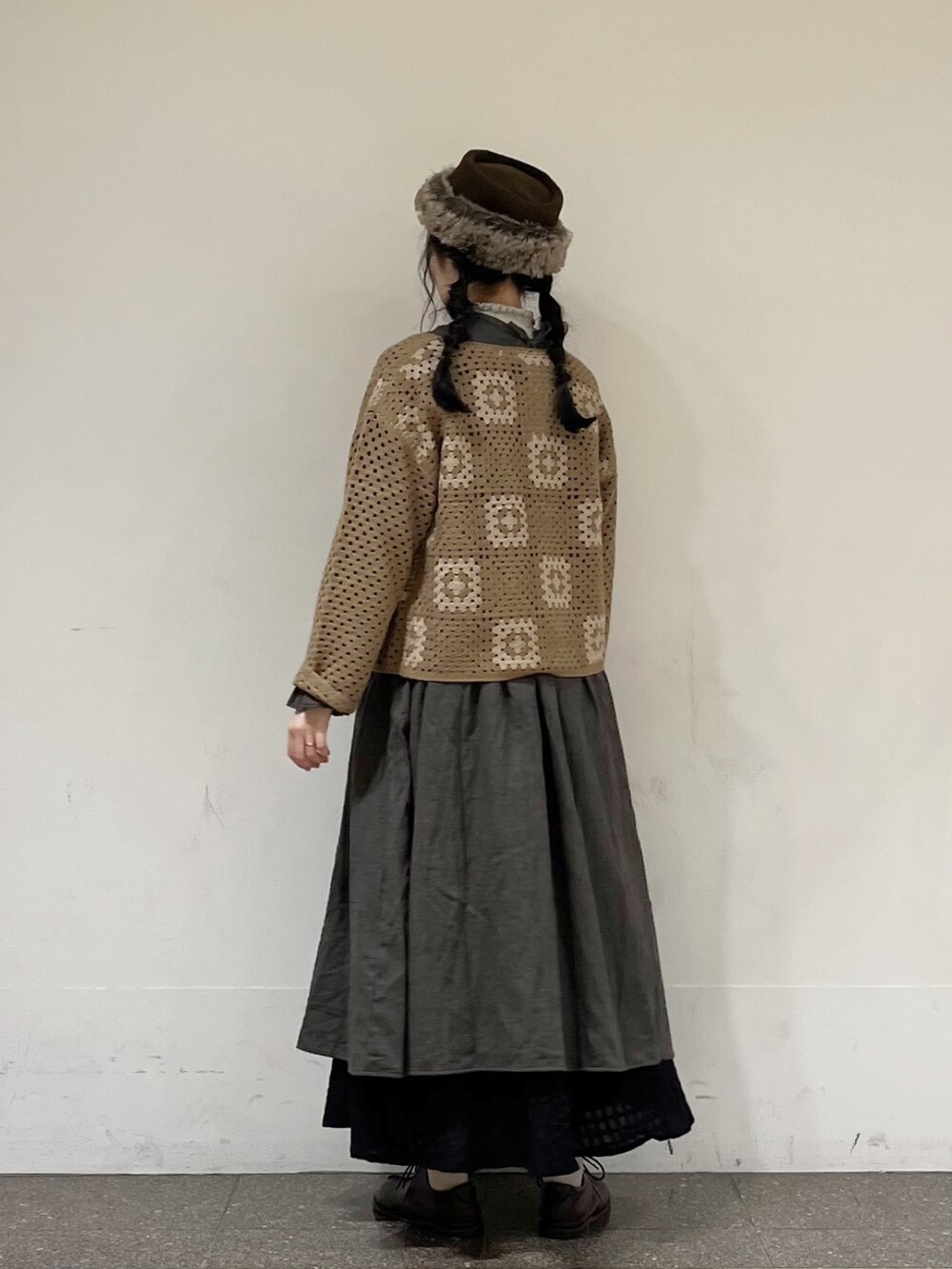 ブルー系のワンピース、ブラウン系のカーディガン/ボレロ、ブラック系のスカートを着用したレディースの秋コーディネートの3枚目の写真