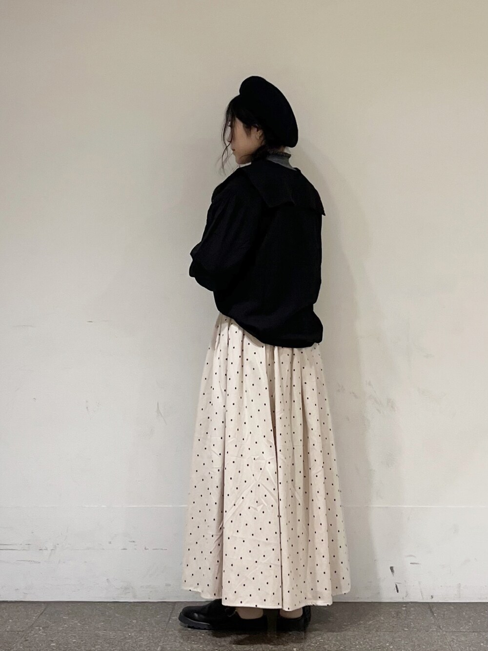 ブラック系のシャツ/ブラウス、グレー系のニット/セーター、ホワイト系のスカートを着用したレディースの秋コーディネートの3枚目の写真