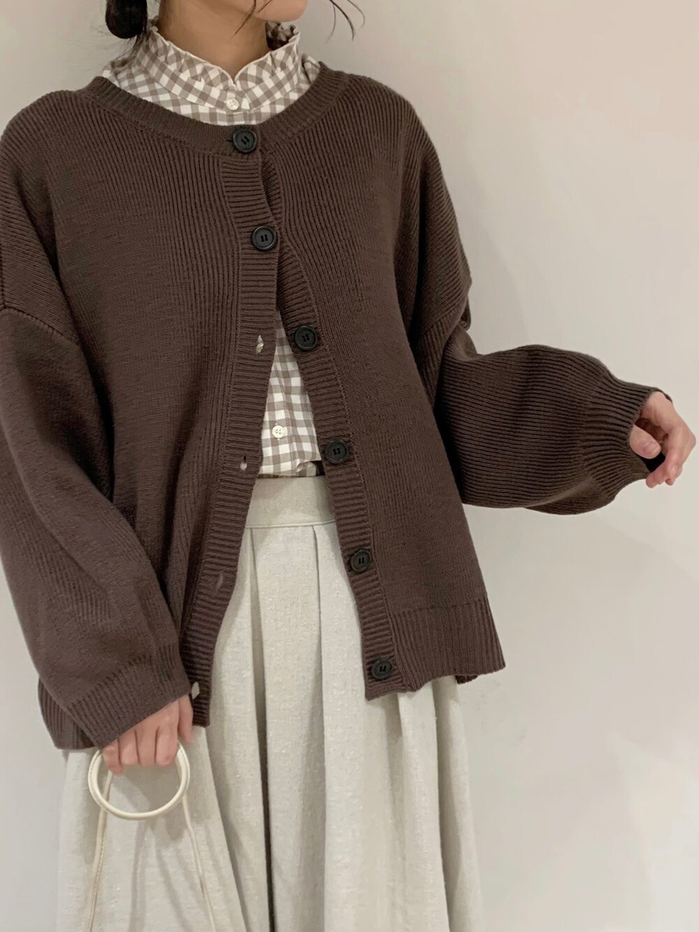 ブラウン系のニット/セーター、ベージュ系のシャツ/ブラウス、ベージュ系のスカートを着用したレディースの冬コーディネートの5枚目の写真