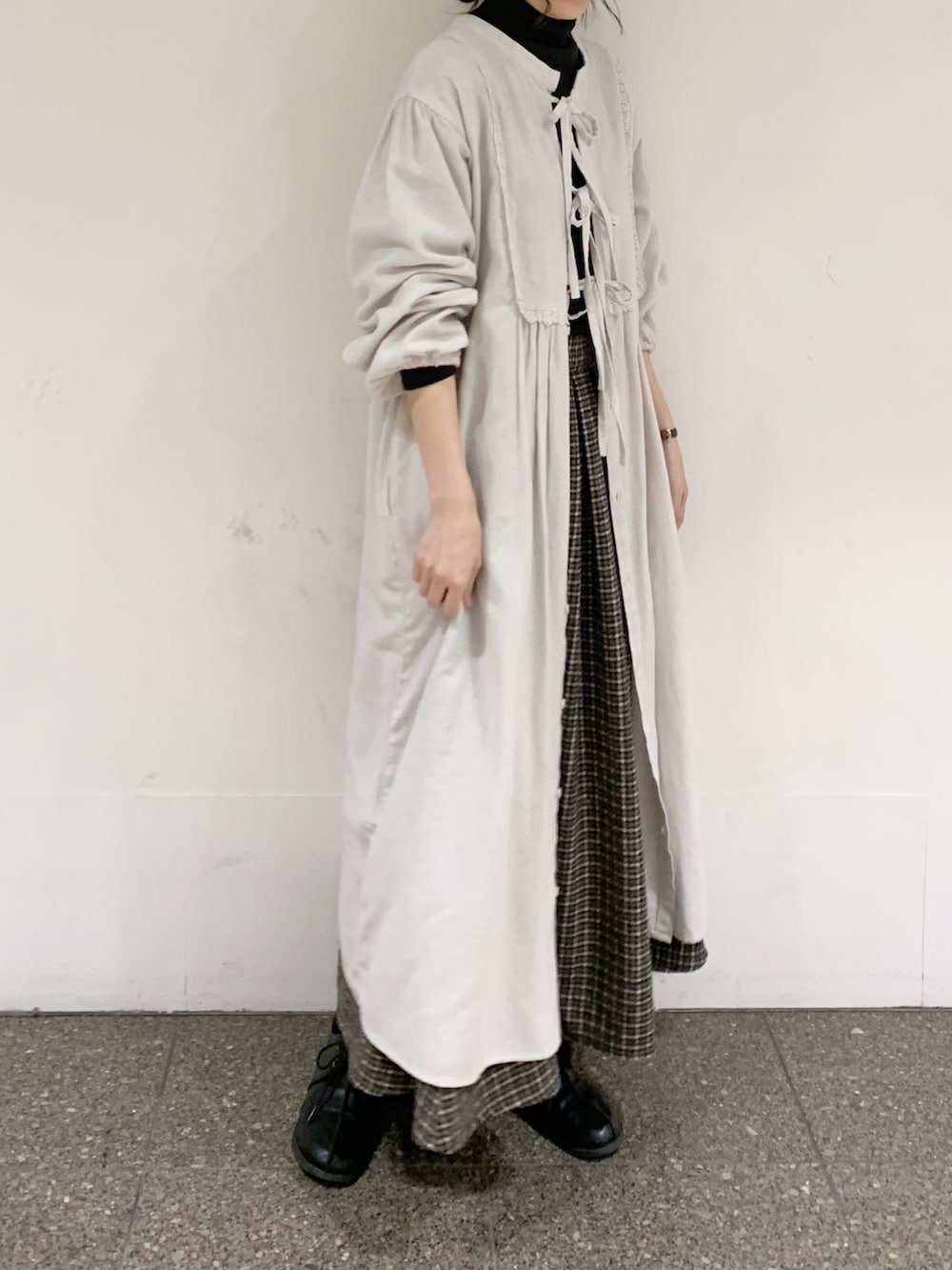 グレー系のワンピース、グレー系のニット/セーター、ブラウン系のスカートを着用したレディースの冬コーディネートの3枚目の写真