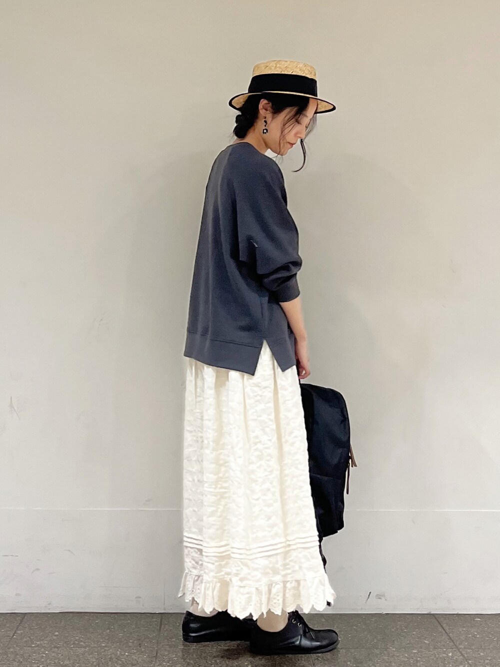 グレー系のTシャツ/カットソー、ホワイト系のスカート、ブラック系のハンドバッグを着用したレディースの冬コーディネートの3枚目の写真