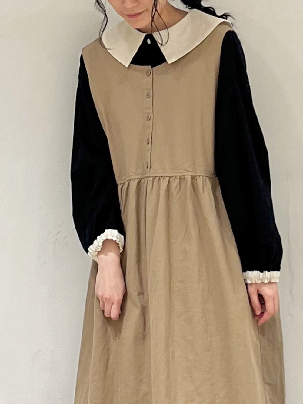 ブラック系のシャツ/ブラウス、ベージュ系のスカート、ベージュ系のワンピースを着用したレディースの冬コーディネートの5枚目の写真