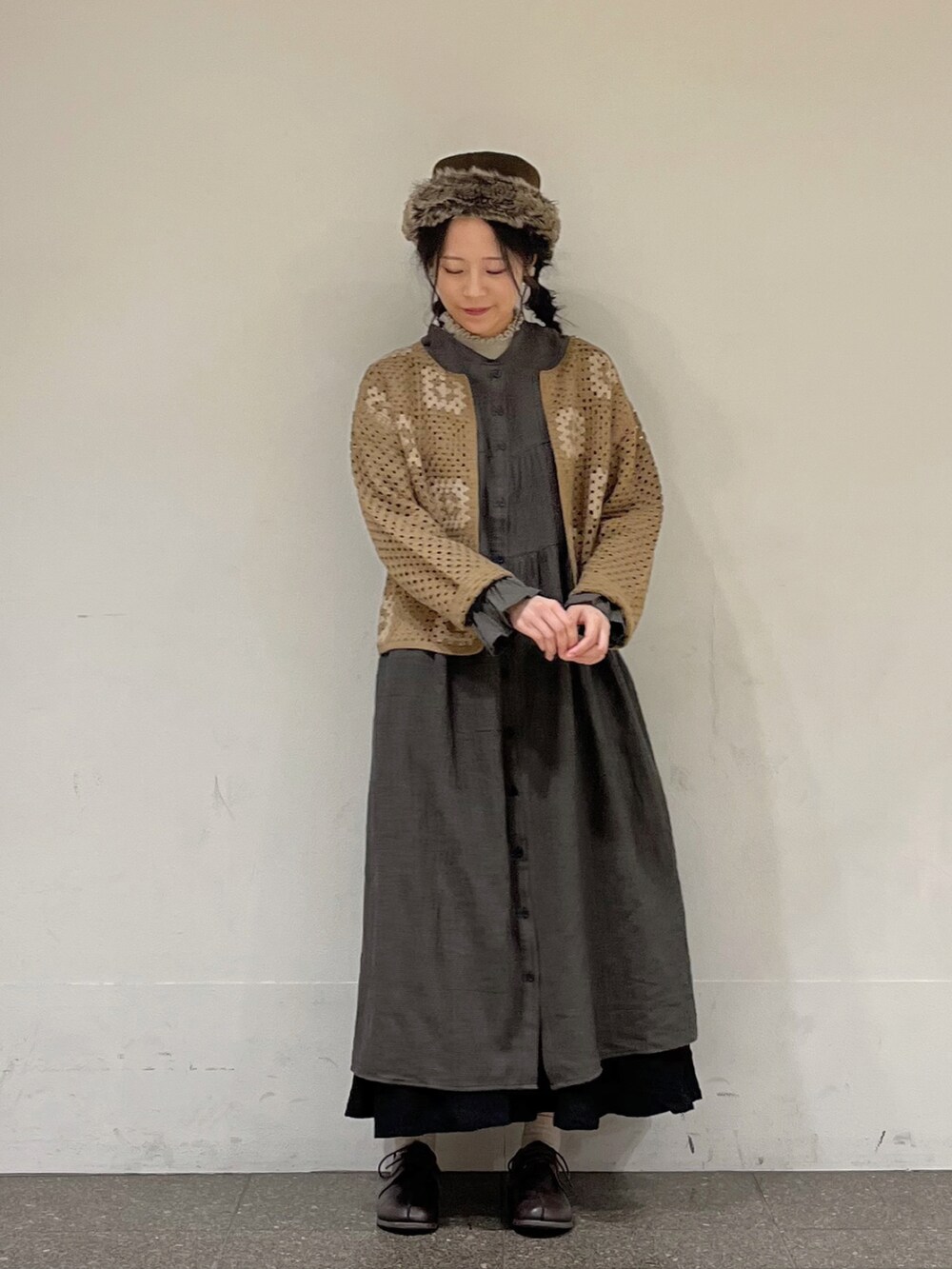 ブルー系のワンピース、ブラウン系のカーディガン/ボレロ、ブラック系のスカートを着用したレディースの秋コーディネートの2枚目の写真