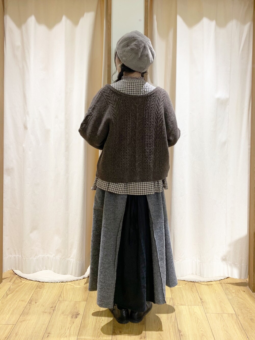 ブラウン系のカーディガン/ボレロ、グレー系のシャツ/ブラウス、ブラック系のスカートを着用したレディースの冬コーディネートの3枚目の写真