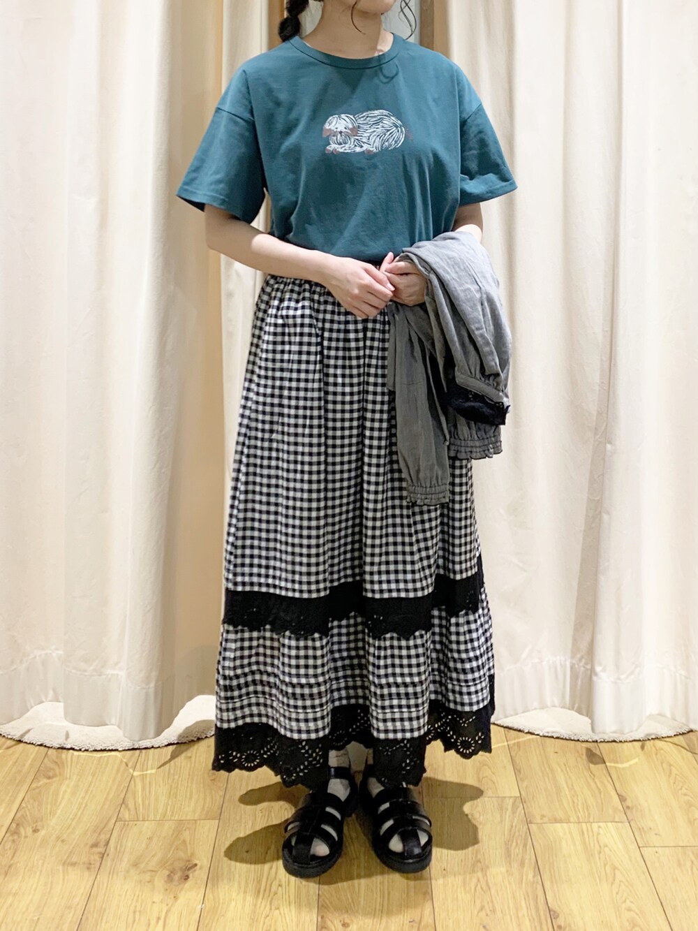 ブラック系のシャツ/ブラウス、グレー系のスカート、グリーン系のTシャツ/カットソーを着用したレディースの春コーディネートの4枚目の写真