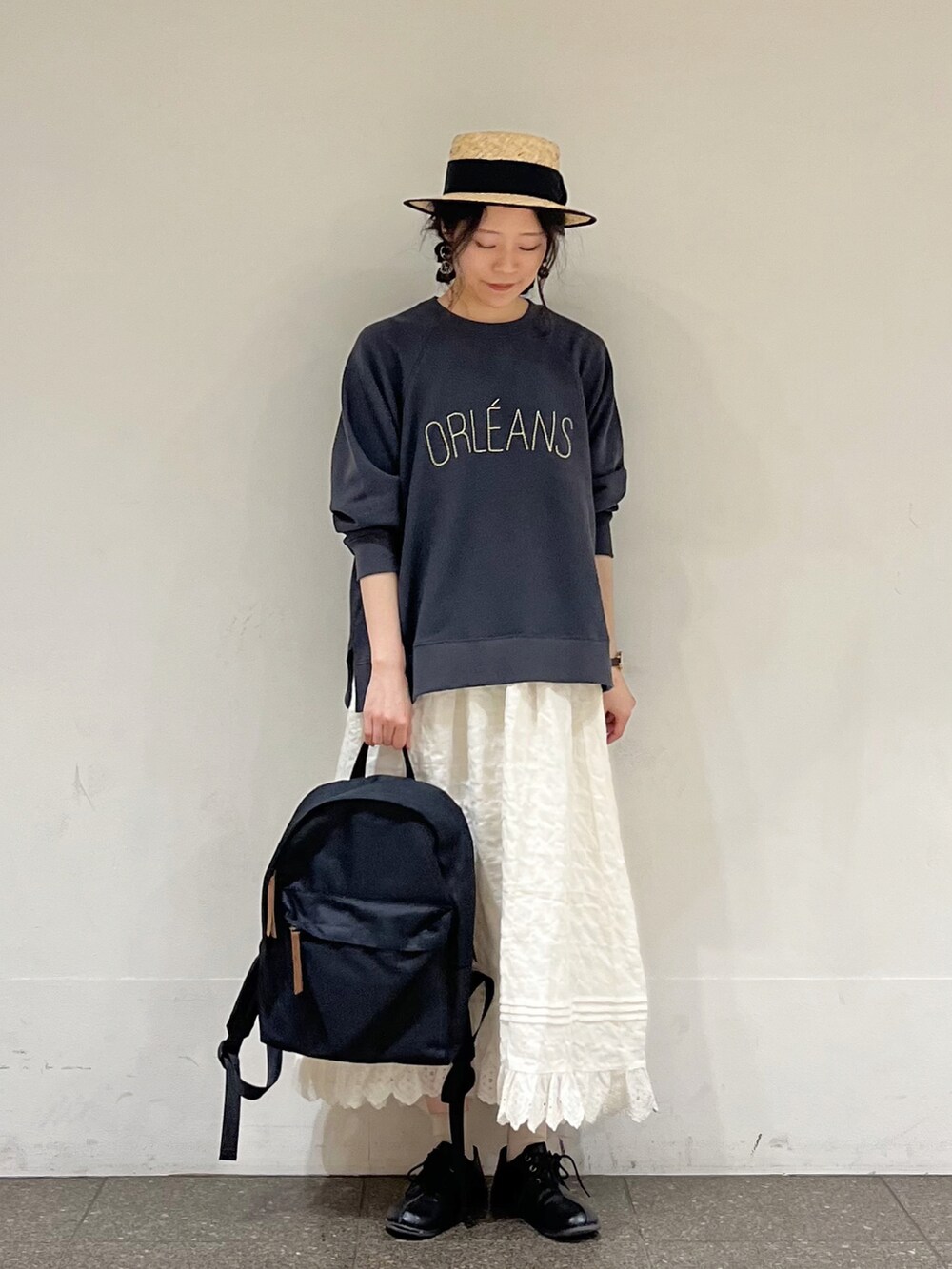 グレー系のTシャツ/カットソー、ホワイト系のスカート、ブラック系のハンドバッグを着用したレディースの冬コーディネートの2枚目の写真