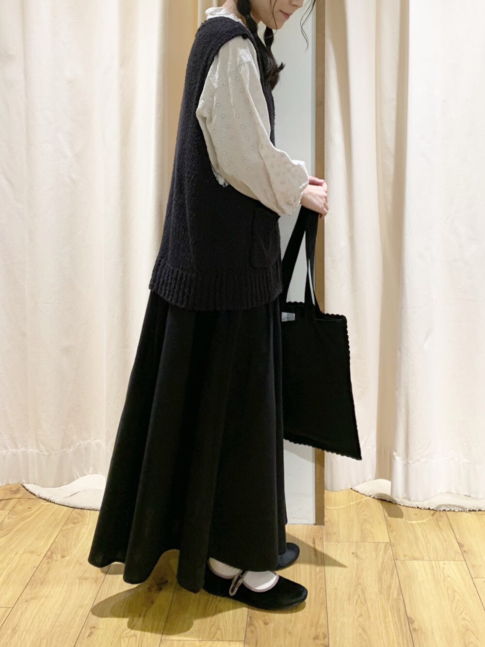 ホワイト系のシャツ/ブラウス、ブラック系のベスト、ブラック系のスカートを着用したレディースの秋コーディネートの2枚目の写真