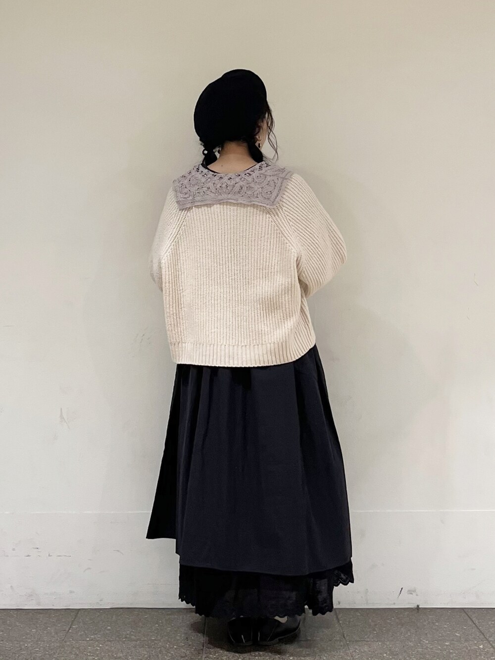 ブラック系のワンピース、ベージュ系のカーディガン/ボレロ、ブラック系のスカートを着用したレディースの春コーディネートの4枚目の写真