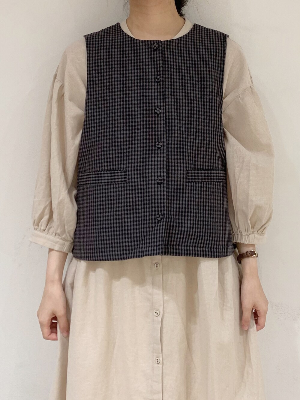 グレー系のベスト、ベージュ系のワンピース、ホワイト系のTシャツ/カットソーを着用したレディースの夏コーディネートの5枚目の写真