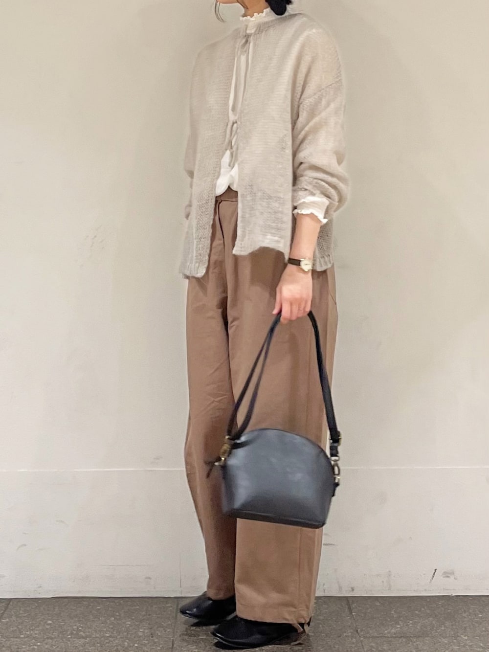 ブラウン系のその他パンツ、ブラック系のハンドバッグ、グレー系のカーディガン/ボレロを着用したレディースの冬コーディネートの3枚目の写真