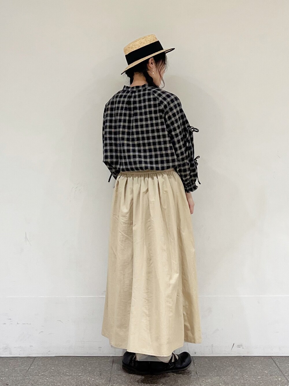 ブラック系のシャツ/ブラウス、ベージュ系のスカート、ブラック系のハットを着用したレディースの冬コーディネートの3枚目の写真