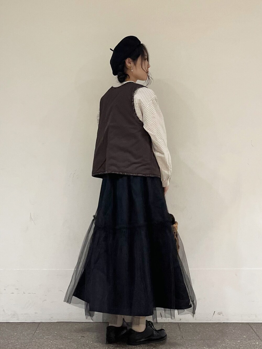 ベージュ系のシャツ/ブラウス、ブラック系のベスト、ブラック系のスカートを着用したレディースの冬コーディネートの3枚目の写真