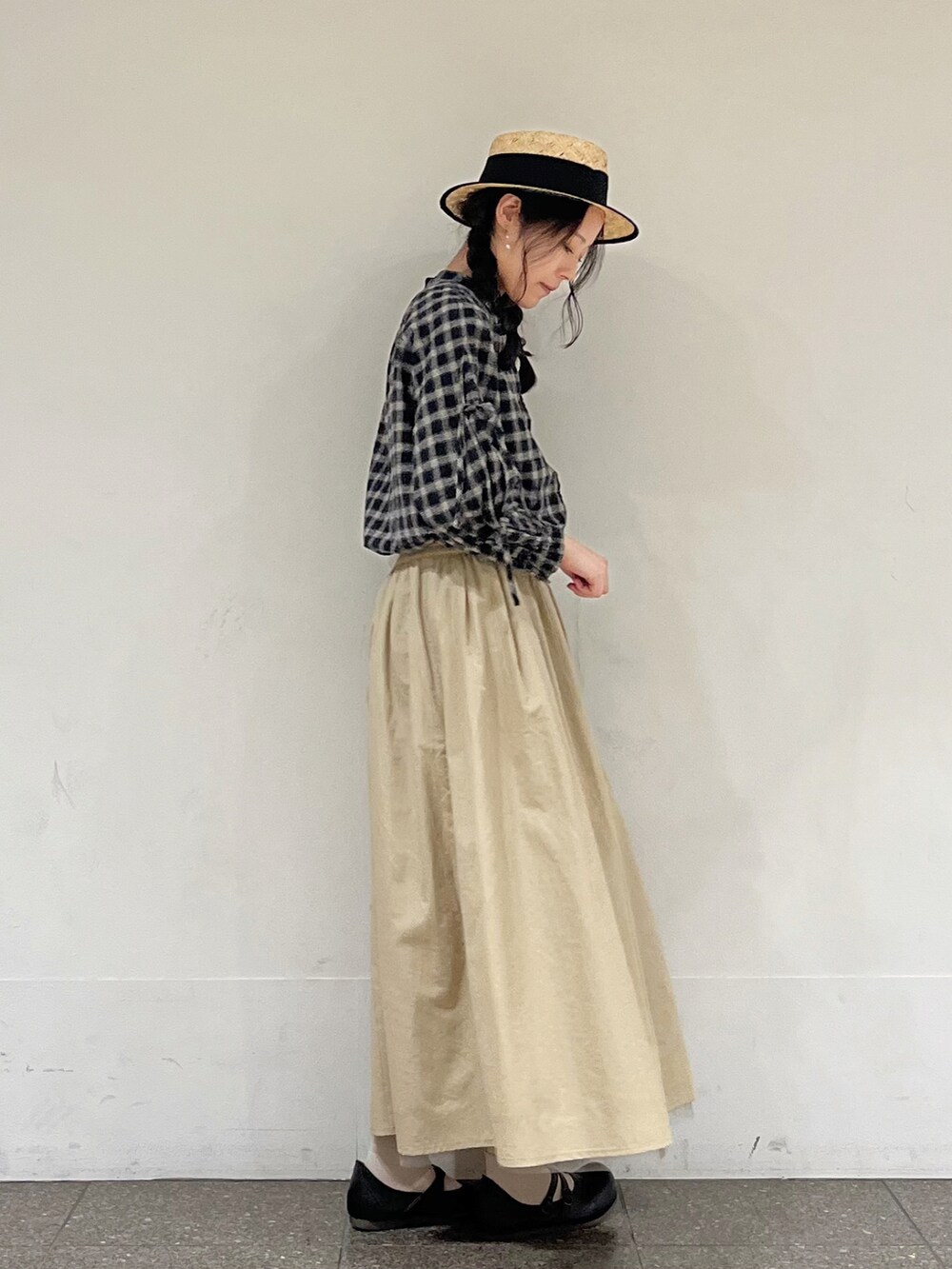 ブラック系のシャツ/ブラウス、ベージュ系のスカート、ブラック系のハットを着用したレディースの冬コーディネートの2枚目の写真