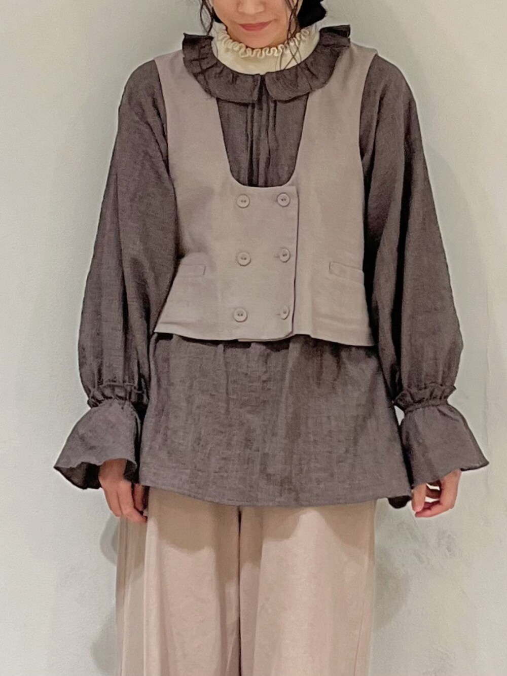 ブラウン系のシャツ/ブラウス、ブラウン系のベスト、ホワイト系のニット/セーターを着用したレディースの冬コーディネートの5枚目の写真