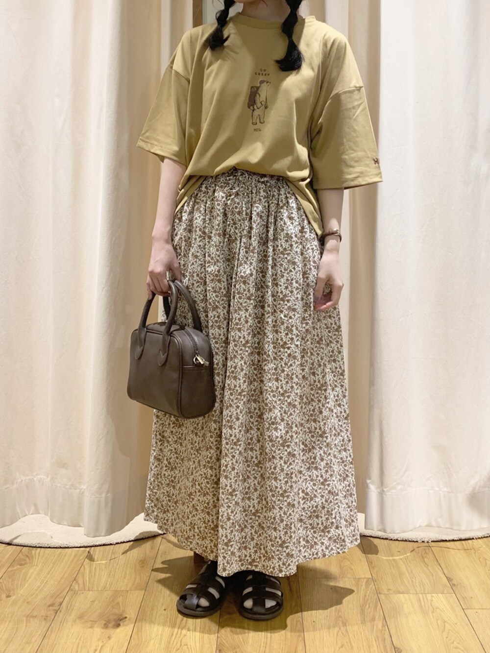 イエロー系のTシャツ/カットソー、オレンジ系のスカート、ホワイト系のTシャツ/カットソーを着用したレディースの春コーディネートの4枚目の写真