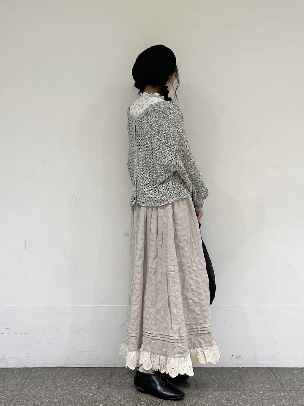 ブルー系のTシャツ/カットソー、ブラック系のカーディガン/ボレロ、ベージュ系のスカートを着用したレディースの冬コーディネートの3枚目の写真